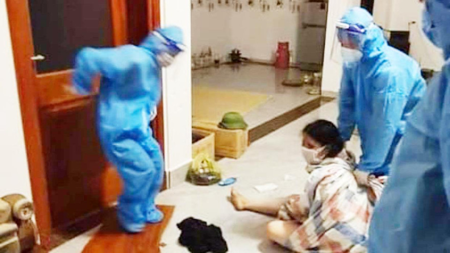 Lực lượng chức năng phải quấn bạt đưa người phụ nữ đi cách ly