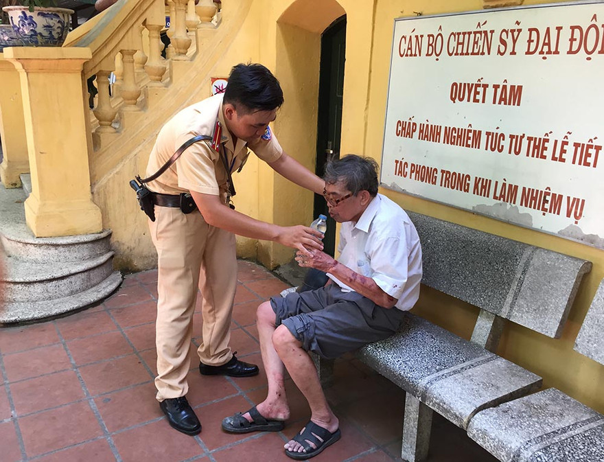 Các chiến sĩ CSGT mua nước và bánh giúp cụ ông hồi phục.