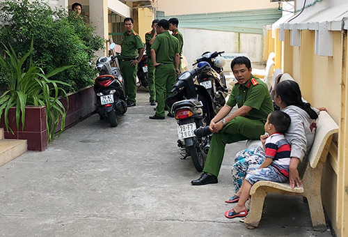 Cảnh sát làm việc với người thân bé trai tại bệnh viện. Ảnh: Xuân Ngọc.