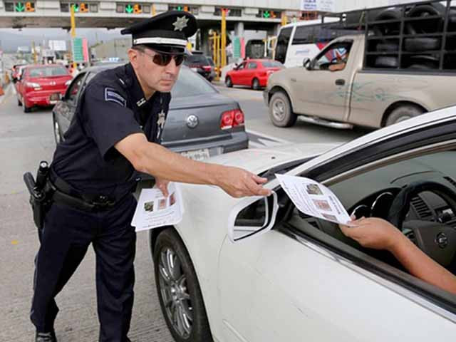 Cảnh sát Mexico phát tờ truy nã "bố già" Joaquin "El Chapo" Guzman cho từng lái xe gần một trạm kiểm soát trên đường cao tốc.