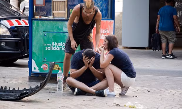 Người Barcelona an ủi nhau sau vụ tấn công kinh hoàng. Ảnh: EAP
