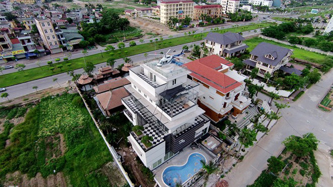 Căn biệt thự rộng 600 m2, được chia thành hai phong cách thiết kế khác nhau. Hướng cửa chính theo lối cổ điển phương Đông với cổng gỗ có phần cách điệu, mặt sau lưng lại mang kiến trúc hiện đại.