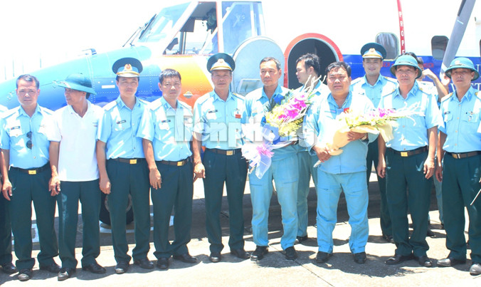 Đồng đội chúc mừng đại tá Lê Kiêm Toàn và thượng tá Nguyễn Đức Hảo (hai người cầm hoa) trở về đơn vị sau khi thực hiện nhiệm vụ bay chuyển sân hạ cánh ở Trường Sa trên một chiếc Casa-212, đầu tháng 6/2016.