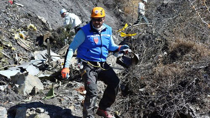 Một điều tra viên Pháp đang đi giữa các mảnh vỡ của chiếc Airbus A320 thuộc hãng hàng không Germanwings. Ảnh: Reuters.