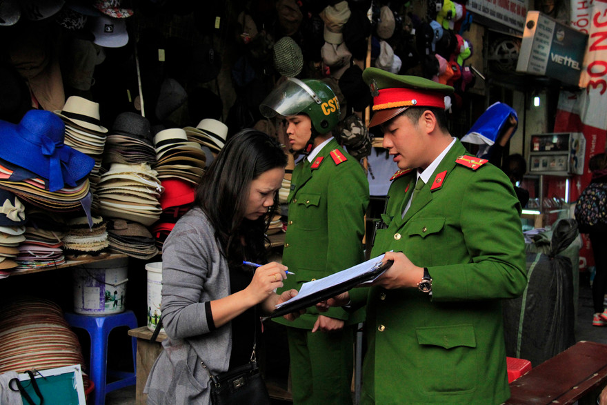 Một hộ dân ký biên bản vi phạm lấn chiếm vỉa hè trên phố Lò Sũ, Ảnh: Trường Phong