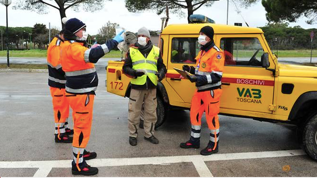 Các tình nguyện viên mang khẩu trang đến nhà người dân ở Grosseto, Italy. (Ảnh: Reuters)