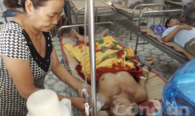 Ông Thống được vợ chăm sóc tại bệnh viện.