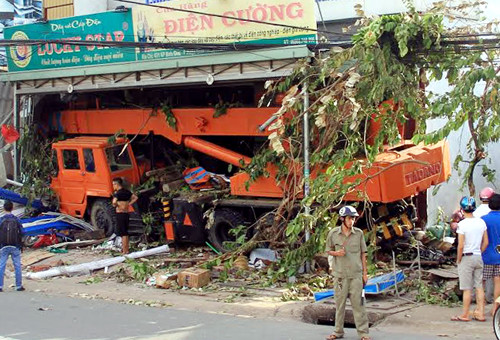 Xe cẩu đã tông 4 người rồi lao vào cửa hàng điện. Ảnh: Nguyệt Triều.