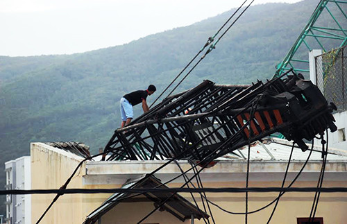 Cần cẩu công trình đè lên mái nhà bên cạnh. Ảnh: Quy Nhơn.