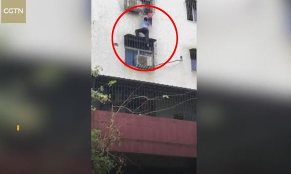 Bé trai bị kẹt đầu trên ban công tầng 3. Ảnh cắt từ clip