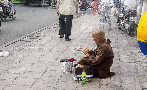 Giả dạng tu hành, thầy Sáu lê la trước cổng bệnh viện để xin tiền.