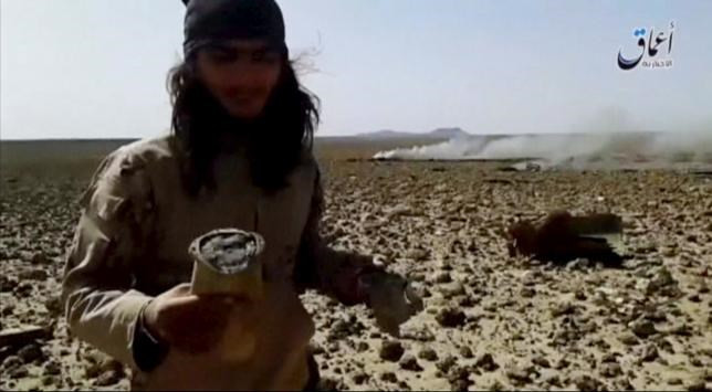 Một người đàn ông đứng gần nơi được cho là mảnh vỡ của chiếc Mig-23 bị rơi hôm 22/4 ở phía Đông Nam thủ đô Damascus. Ảnh: Reuters.