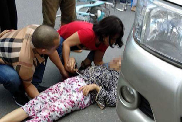 Tài xế Sơn (áo kẻ) và chị M. (vợ Sơn) đỡ nạn nhân sau khi gây tai nạn