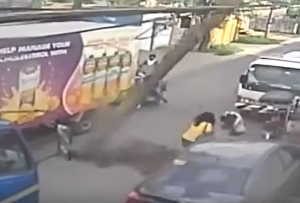 Khoảnh khắc cây đổ trúng người phụ nữ đi đường. Ảnh cắt từ video