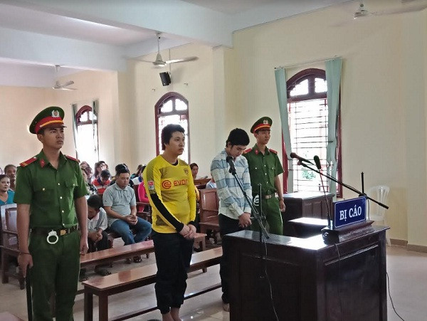 Bị cáo Hiếu (áo vàng), Bình (áo sơ mi sọc) chờ nghe tuyên án. Ảnh: Kim Hà.