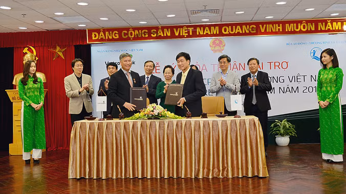 Đại diện Vietcombank, ông Nguyễn Danh Lương - Ủy viên HĐQT, Phó Tổng giám đốc (hàng đầu bên trái) và đại diện Quỹ BTTE, ông Hoàng Văn Tiến - Giám đốc ký thỏa thuận tài trợ và nhận tài trợ.