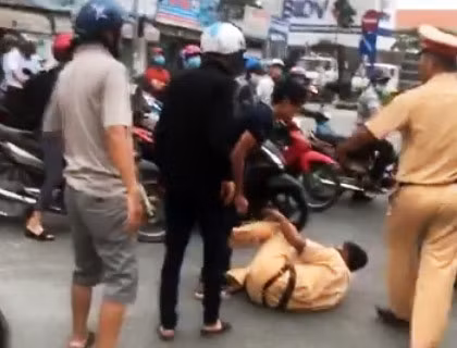 Cảnh sát giao thông bị 3 anh em An xô ngã. Ảnh: Cắt từ video
