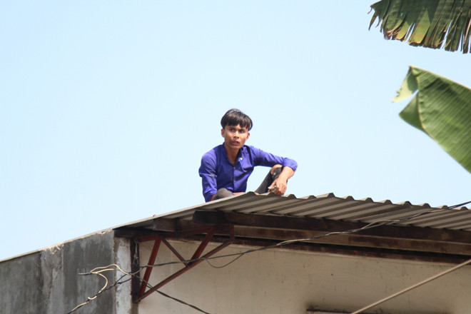Nam thanh niên cố thủ trên mái nhà dân