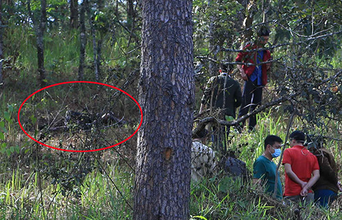 Cảnh sát khám nghiệm hiện trường nơi thi thể nạn nhân (khoanh tròn đỏ) cháy đen