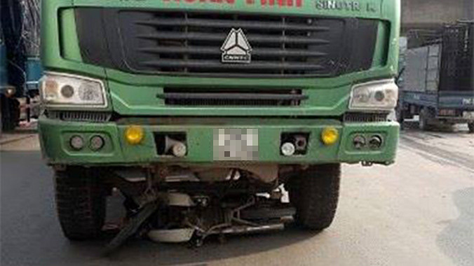 Chiếc xe máy vẫn nằm gọn dưới gầm xe tải.