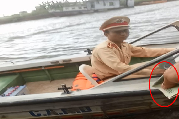 CSGT đường thủy trạm Khánh Tiên (Ninh Bình) ngồi trên cano nhận tiền từ chủ tàu.