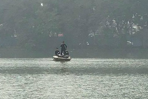 Lực lượng cứu hộ dùng phương tiện đi ra giữa hồ tìm kiếm nạn nhân.