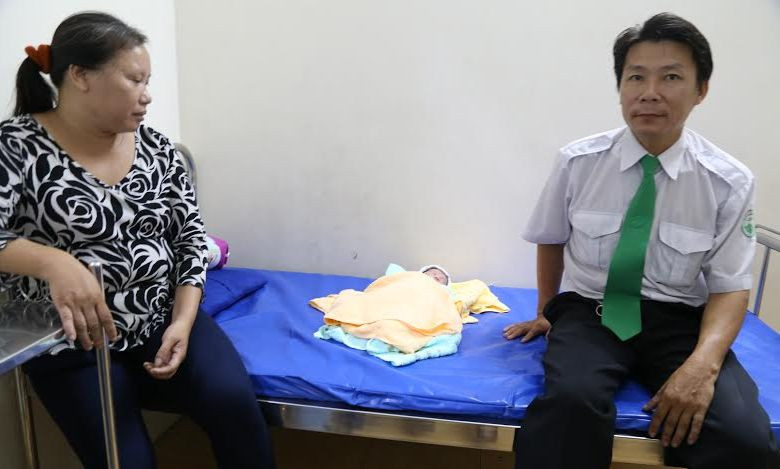 Lái xe Nguyễn Trọng Tài bên cháu bé được sinh ra trên xe taxi.