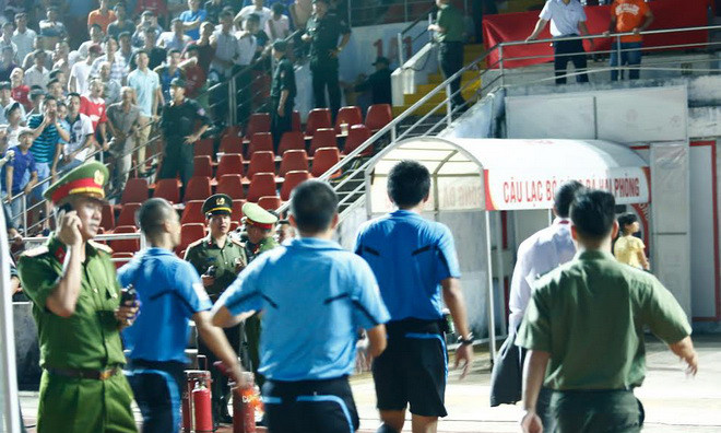 Tổ trọng tài rời sân trong sự hộ tống của nhân viên an ninh. Ảnh: Thanh Hà.