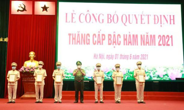 Trung tướng Nguyễn Hải Trung Giám đốc Công an TP Hà Nội trao quyết định thăng cấp bậc hàm cho trưởng các phòng, trưởng Công an các quận, huyện. 
