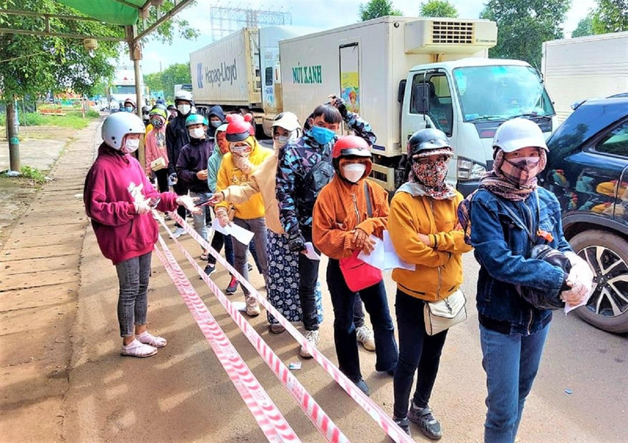 Đoàn người xếp hàng khai báo y tế khi qua địa phận Cư Jút (Đắk Nông)