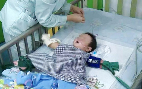 Bé Khang trong tình trạng nguy hiểm khi đến cấp cứu tại bệnh viện. Ảnh: Xinhuanet.