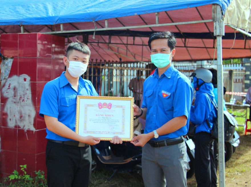 Đại diện lãnh đạo tỉnh đoàn (phải) khen thưởng, động viên Phạm Hữu Trí