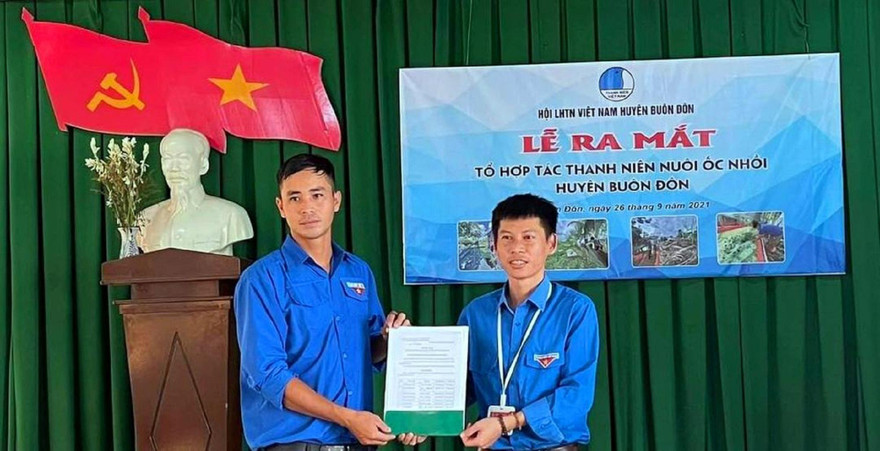 Bí thư huyện Đoàn (phải) và anh Hội trong lễ ra mắt tổ hợp tác thanh niên nuôi ốc nhồi