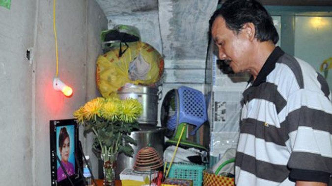 Ông Minh (bố chị Ngân) lặng người bên bàn thờ con gái.