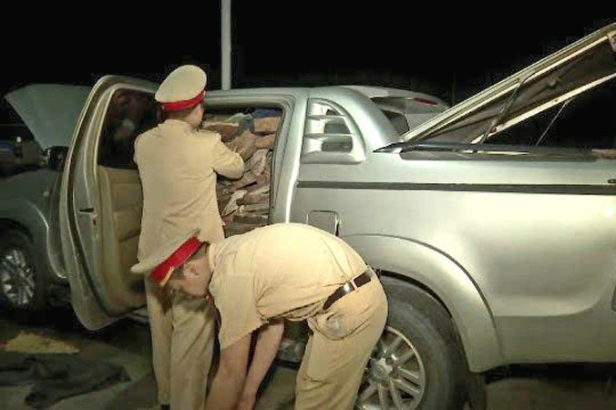 Lực lượng CSGT kiểm tra số gỗ trắc lậu trên xe ôtô bán tải hiệu Toyota Hilux 29C - 01268 do Trần Văn Tuyến điều khiển. Ảnh: CA.