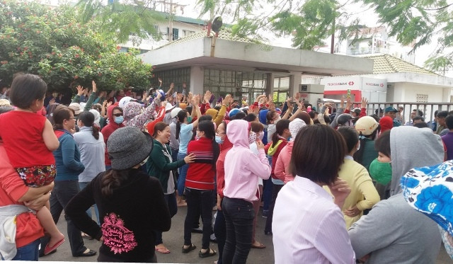 Công nhân tập trung trước cổng công ty để phản đối giảm lương.