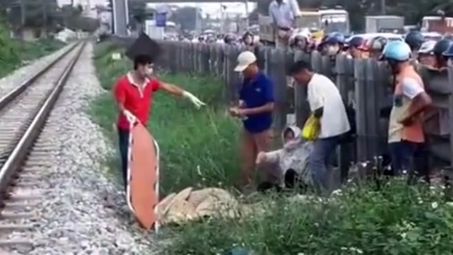 Lực lượng chức năng đang giải quyết vụ tai nạn, đưa nạn nhân ra khỏi khu vực đường tàu