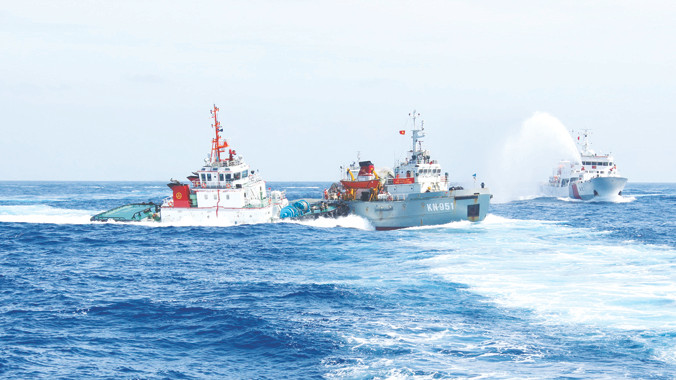 Tàu kiểm ngư của Việt Nam (giữa) bị các tàu Trung Quốc đâm, phun vòi rồng. Ảnh: Việt Cường 