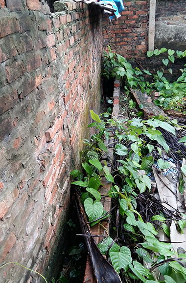 Khe tường, cạnh nhà nghi can, nơi giấu xác nữ sinh. Ảnh: Phương Sơn