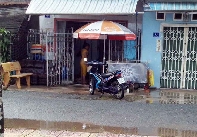 Hiện trường án mạng trước căn nhà có chiếc dù che. Ảnh: Việt Tường