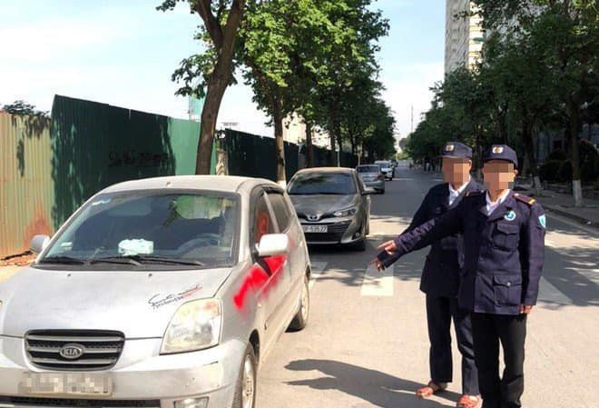 Nhóm bảo vệ xịt sơn vào xe ô tô đỗ dưới lòng đường.