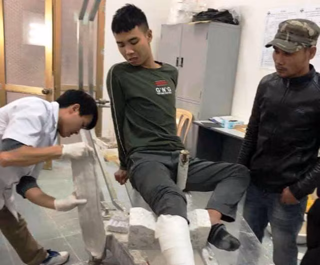 Đối tượng Nguyễn Trung Anh được đưa đi băng bó chữa trị sau khi nhảy từ tầng 3 trường tiểu học Lương Khánh Thiện xuống đất