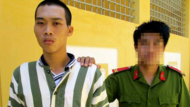 Long (trái) bị công an dẫn giải về phòng giam