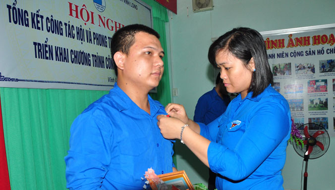 Chị Nguyễn Huỳnh Thu (bên phải) gắn huy hiệu tuổi trẻ dũng cảm cho anh Duy.