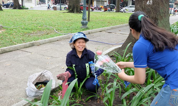 Một nữ công nhân dọn vệ sinh cảm động, bật khóc khi nhận được hoa từ tay các bạn sinh viên.