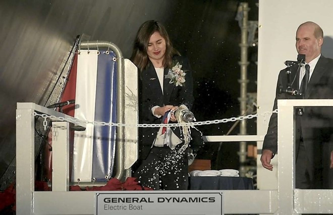 Annie Mabus, con gái Bộ trưởng Hải quân Ray Mabus cũng là nhà tài trợ, đập chai rượu vang trong nghi lễ hạ thủy. Ảnh: AP.