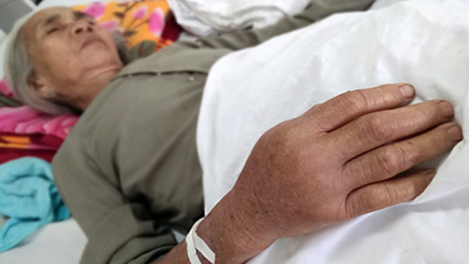 Cụ Điềm bị rắn lục đuôi đỏ cắn đang nằm điều trị tại Bệnh viện đa khoa Tây Hòa. Ảnh: Ngọc Thắng.