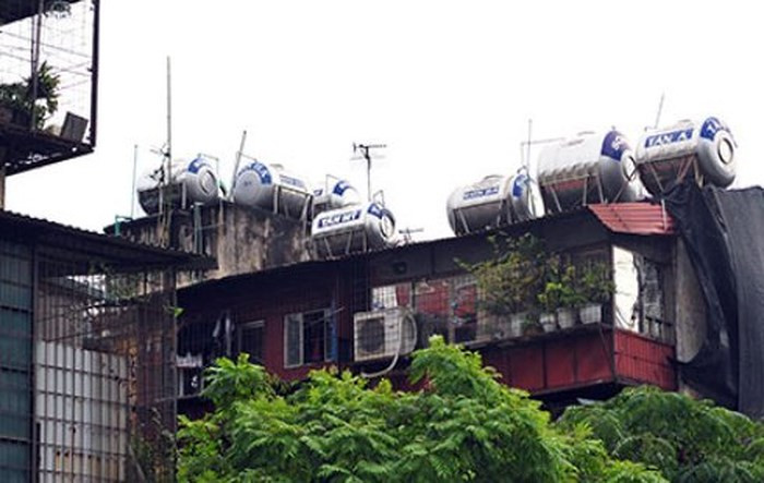 Bể nước inox chen chúc nhau trên nóc nhà các khu tập thể cũ.