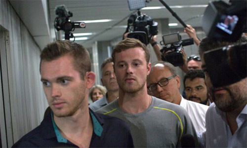 Gunnar Bentz (trái) và Jack Conger rời một đồn cảnh sát ở Rio hôm 18/8. Ảnh: AP.