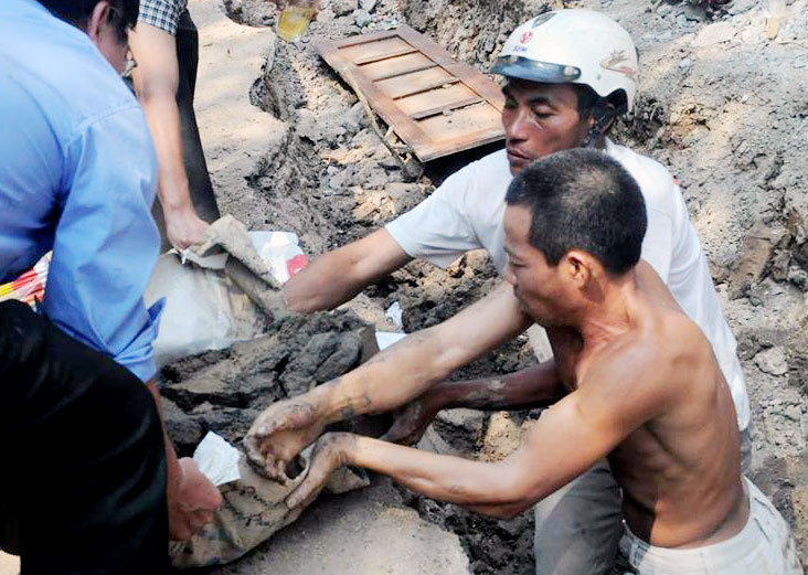 Các công nhân đưa những bộ hài cốt lên.